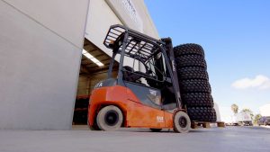 Military vehicle traversing rough landscape with high-performance heavy duty wheels.